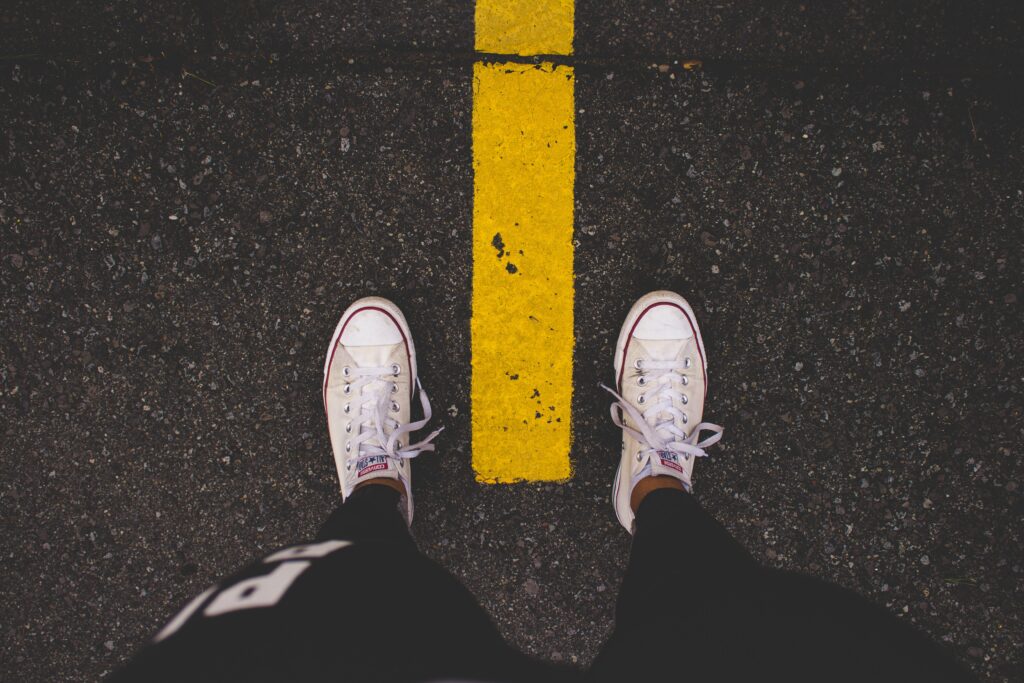 Eine Läuferin steht auf der Straße, zu sehen sind ihre Sporthose und Sneaker