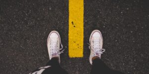 Eine Läuferin steht auf der Straße, zu sehen sind ihre Sporthose und Sneaker